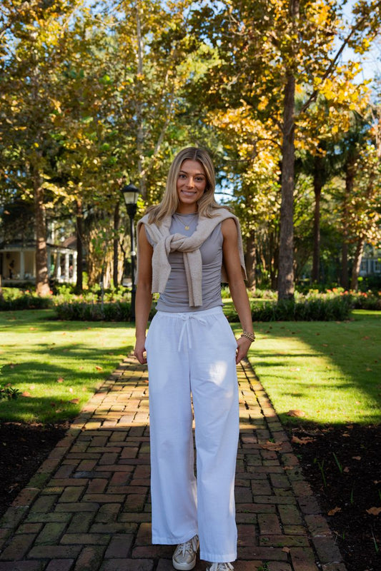 Woman wearing Elody white organic cotton Palazzo Pants with a neutral top and sweater